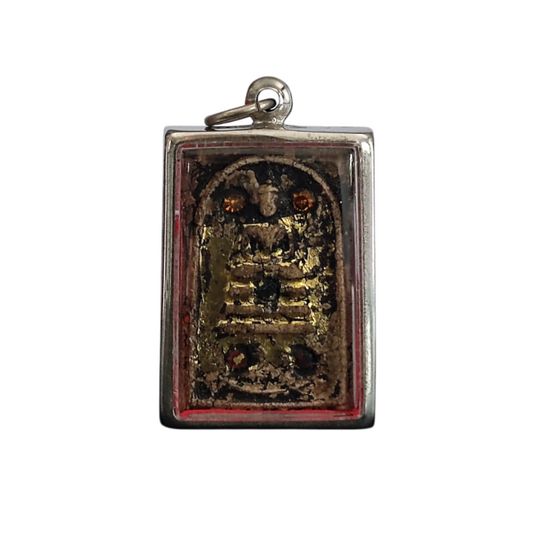 Close-up of a Thai Phra Somdej amulet in a wooden casing